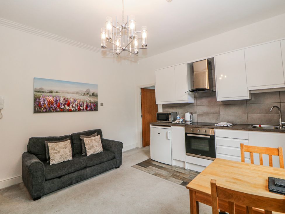 A kitchen area with a dining table and sofa at Gulliver's (76) Matlock