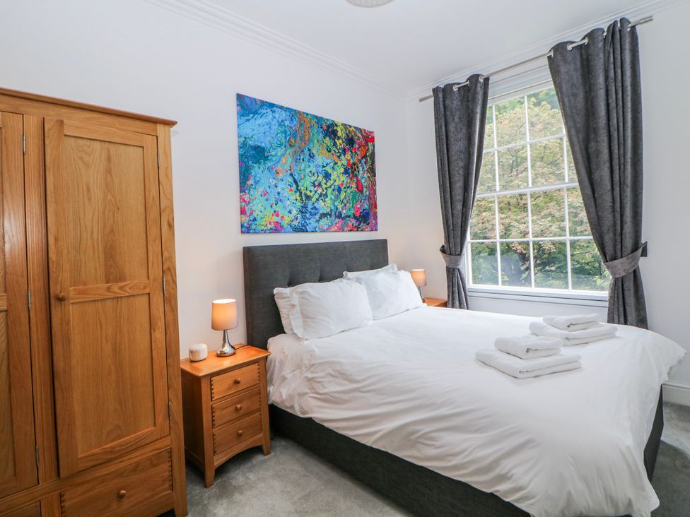 A bedroom with a bed and wardrobe at Gulliver's (76) Matlock