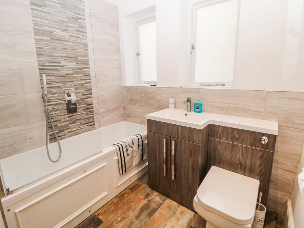 A bathroom with a bathtub, shower, sink, and toilet at Gulliver's (76) Matlock