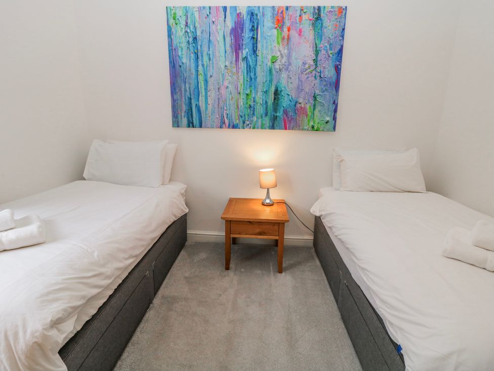 A bedroom with two beds and a lamp at Abraham in Matlock