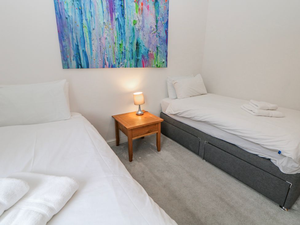 A bedroom with two beds and a table at Abraham in Matlock