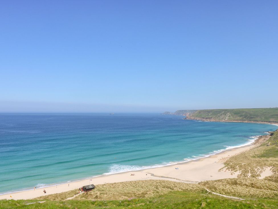 A beach with sand dunes and ocean view at Sunset in St Just