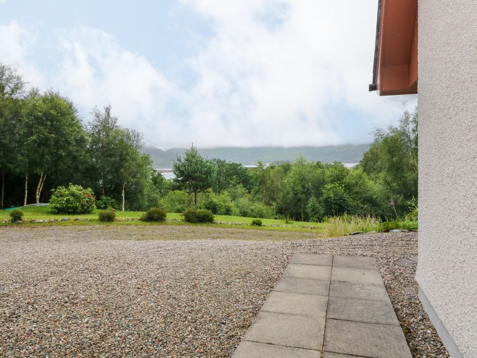 A view of trees and mountains from a gravel pathway at Thistle Do in Lochailort
