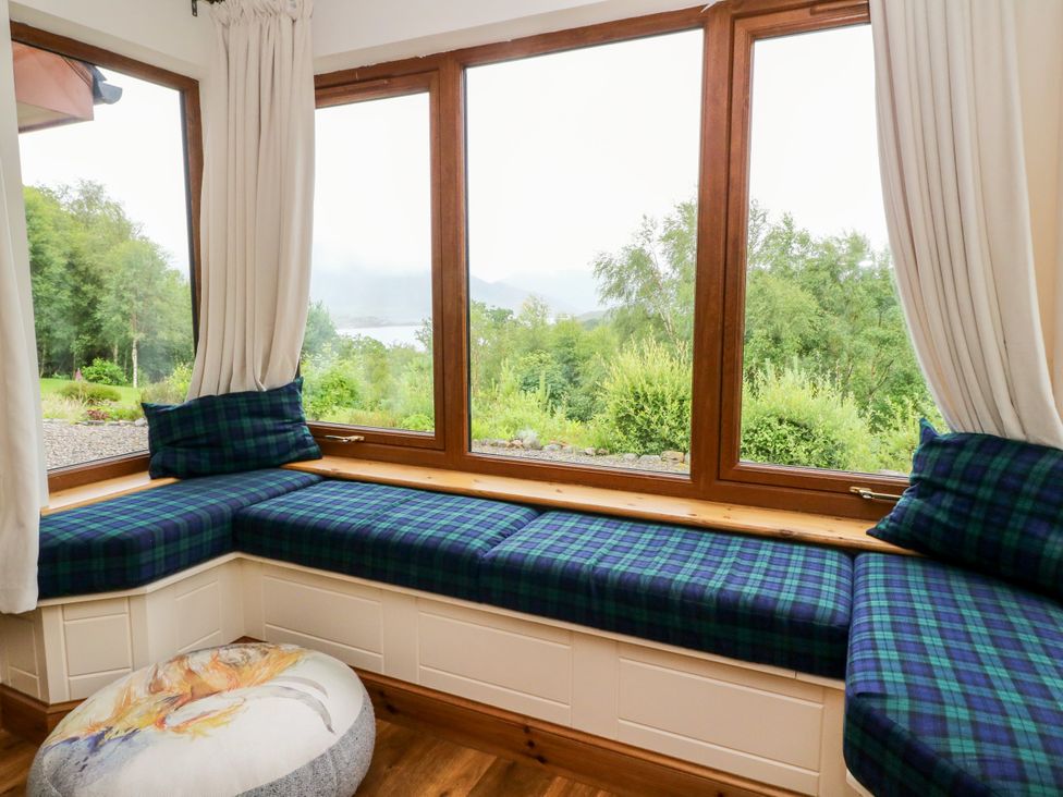A snug with a window seat and cushions at Thistle Do Lochailort