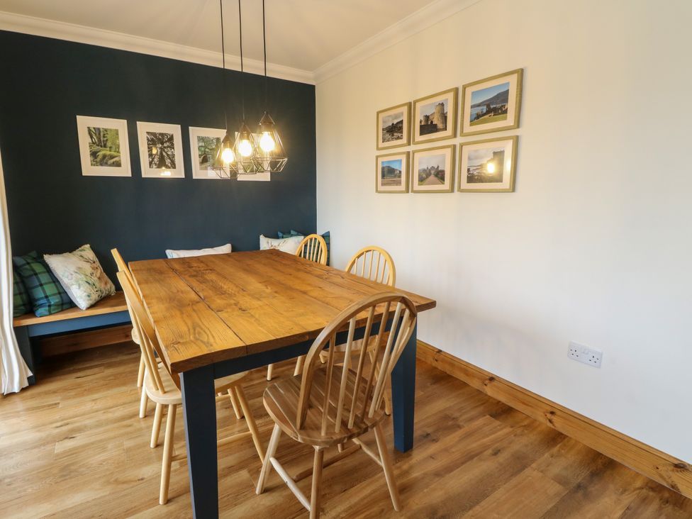 A dining room with a wooden table and chairs at Thistle Do in Lochailort