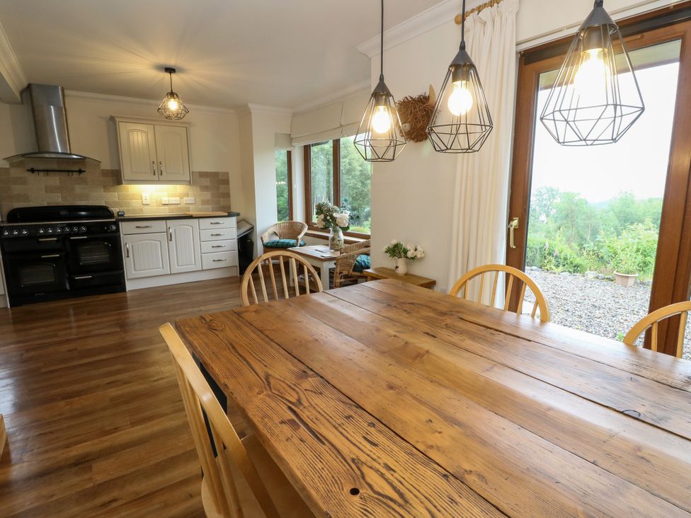 A kitchen with a dining table and chairs at Thistle Do Lochailort