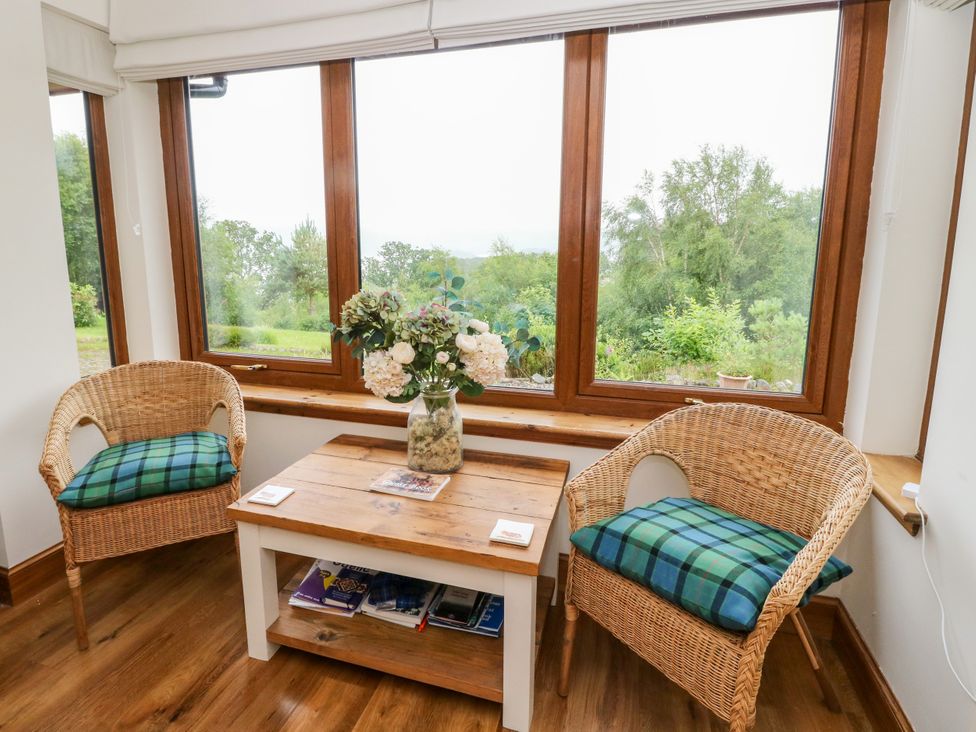 A conservatory with two chairs and a coffee table at Thistle Do Lochailort