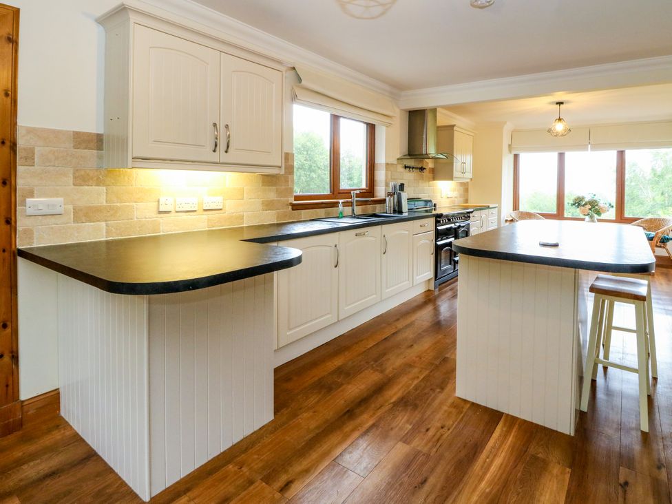 A kitchen with cabinets and an island at Thistle Do in Lochailort