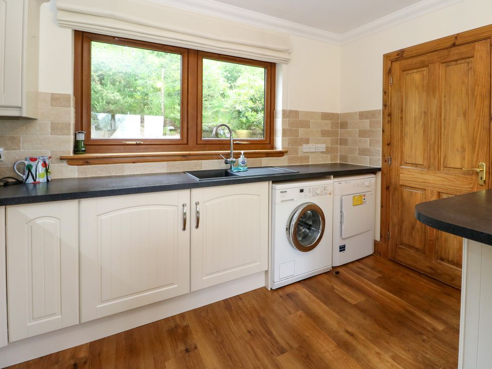 A kitchen with a sink and washing machine at Thistle Do Lochailort
