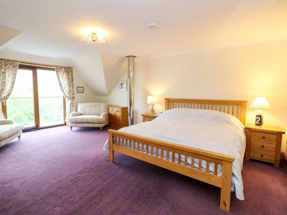A bedroom with a bed and sofas at Thistle Do in Lochailort