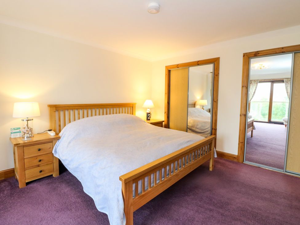 A bedroom with a bed and nightstand at Thistle Do in Lochailort