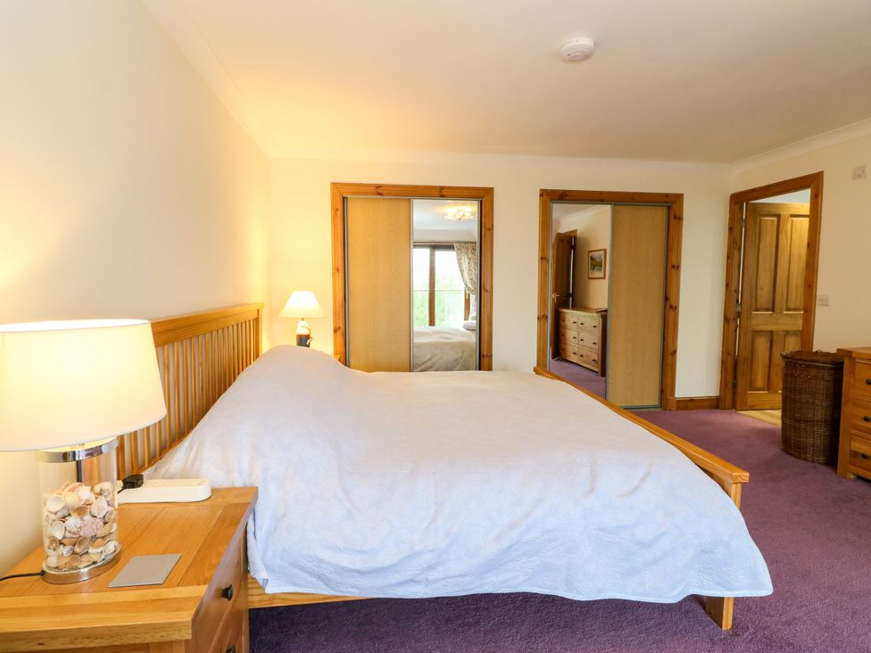 A bedroom with a bed and a bedside table at Thistle Do in Lochailort