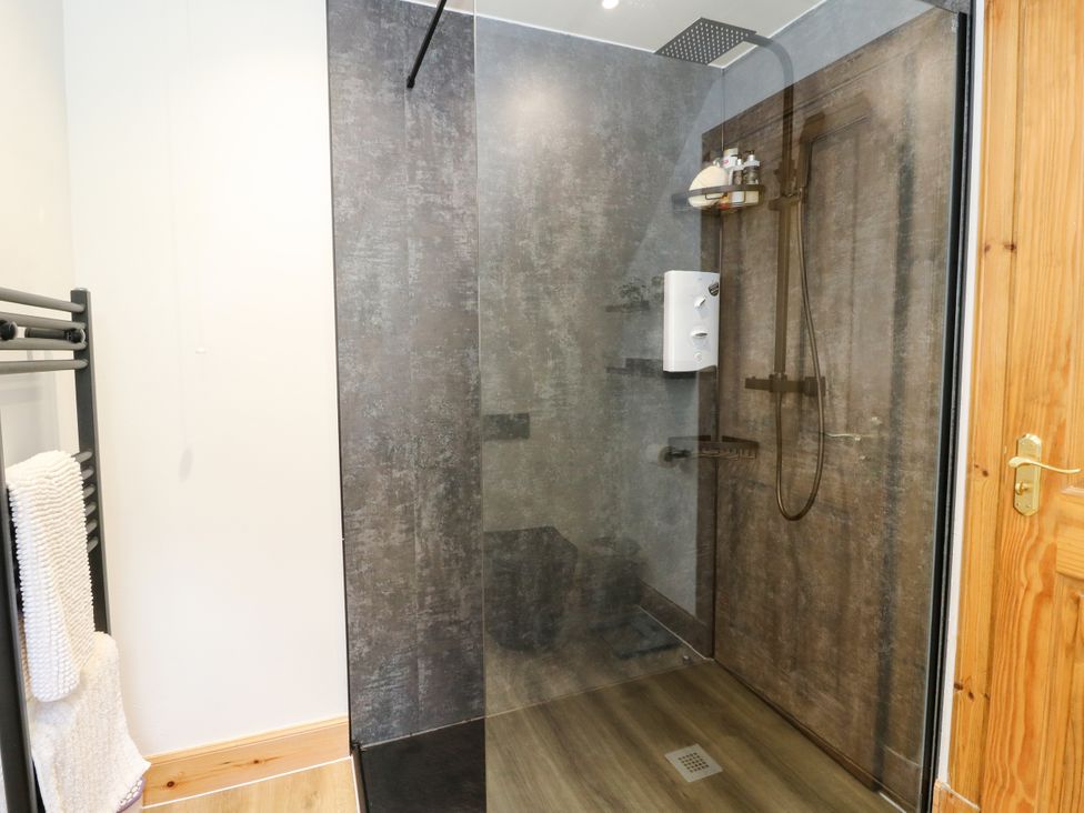 A shower with glass enclosure and towel rack at Thistle Do in Lochailort