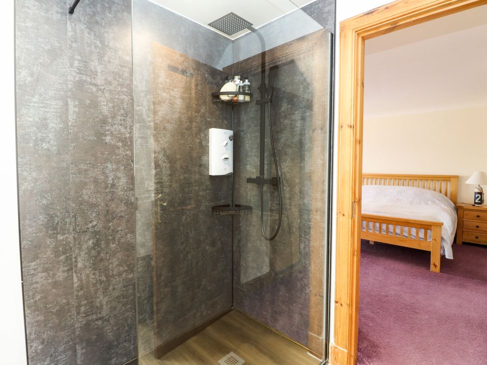 A shower with a soap dispenser and shelf at Thistle Do in Lochailort