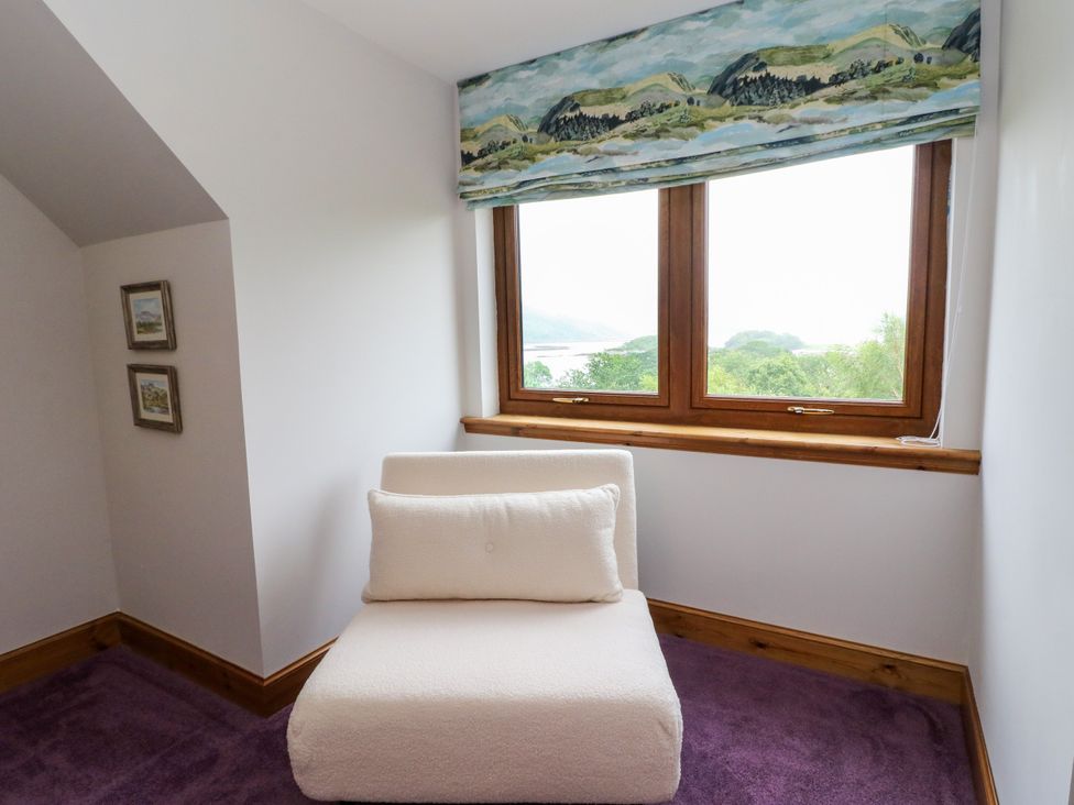 A snug with a chair and paintings at Thistle Do in Lochailort