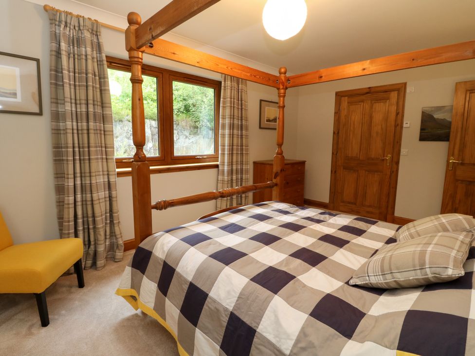 A bedroom with a bed and windows at Thistle Do in Lochailort