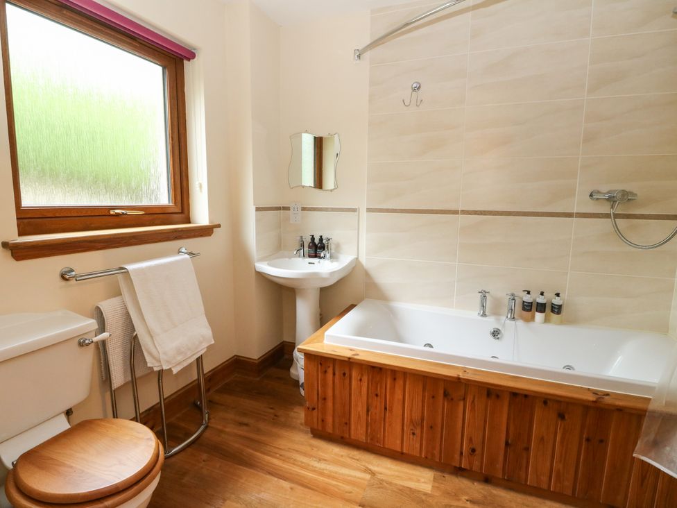 A bathroom with a bathtub, toilet, and sink at Thistle Do in Lochailort