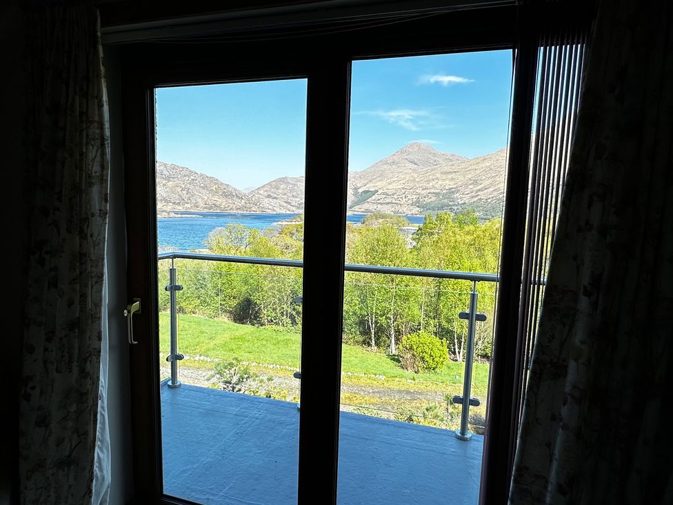 A view from a window overlooking mountains and a lake at Thistle Do in Lochailort