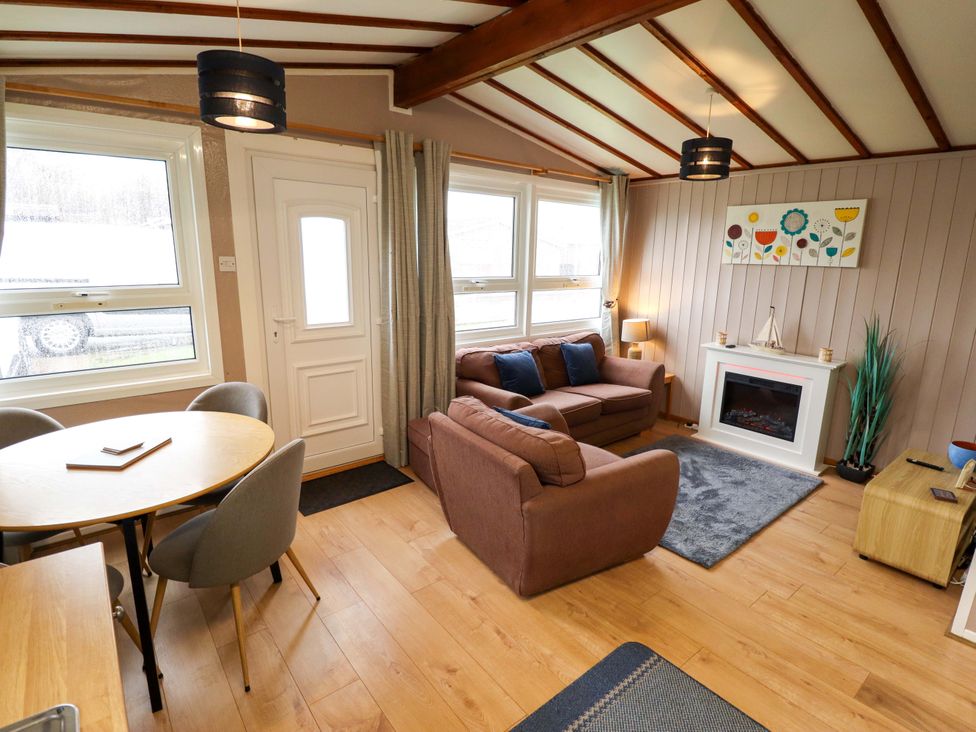 A living room with a sofa and dining table at Moggs Retreat in Chapel St Leonards