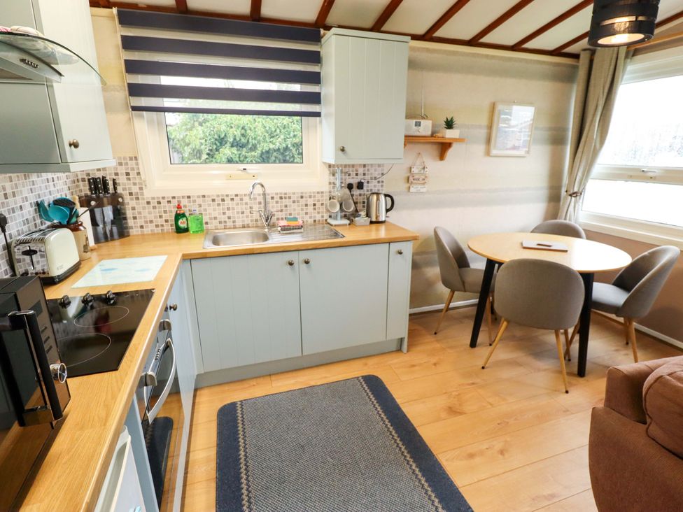A kitchen with a sink and stove at Moggs Retreat in Chapel St Leonards