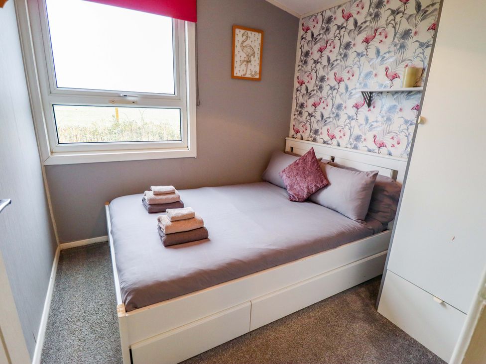 A bedroom with a bed and window at Moggs Retreat Chapel St Leonards
