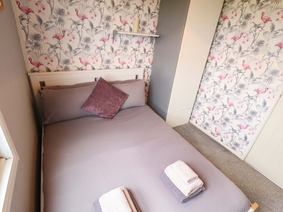 A bed with pillows and towels in a bedroom at Moggs Retreat in Chapel St Leonards