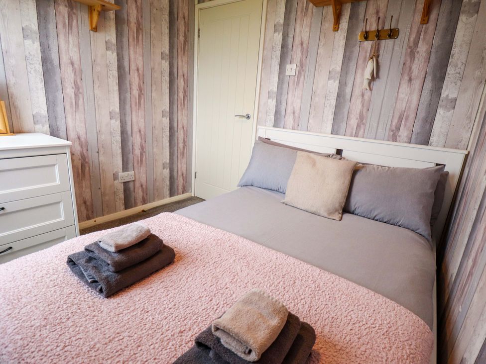A bedroom with a bed and dresser at Moggs Retreat in Chapel St Leonards