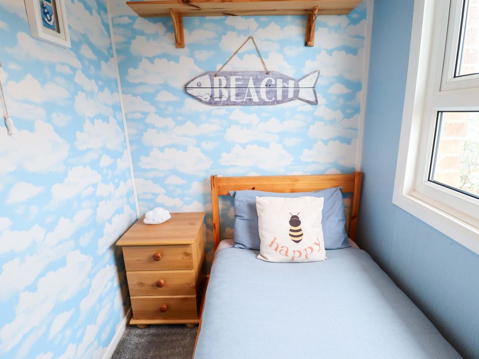 A bedroom with a bed and nightstand at Moggs Retreat in Chapel St Leonards