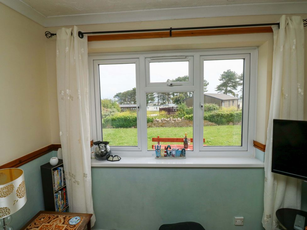A living room with a window and television at Cottage 28 in Brixham
