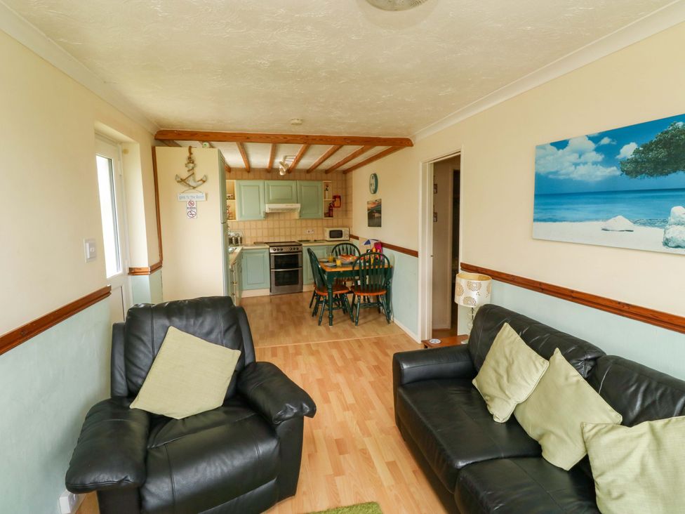 A living room with a sofa and dining area at Cottage 28 in Brixham