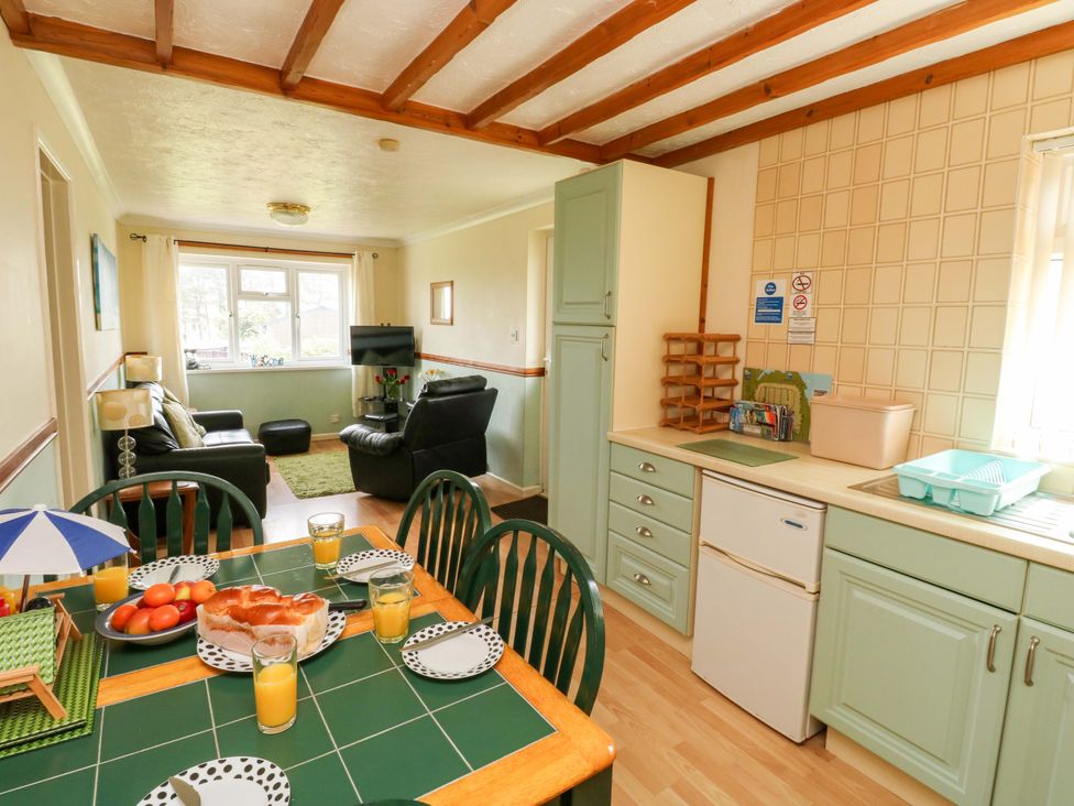 A kitchen and dining area with a table and chairs at Cottage 28 in Brixham