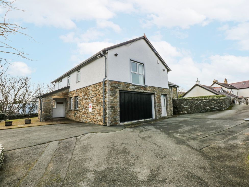A house with a garage and driveway at Bwthyn Alberts Trearddur Bay