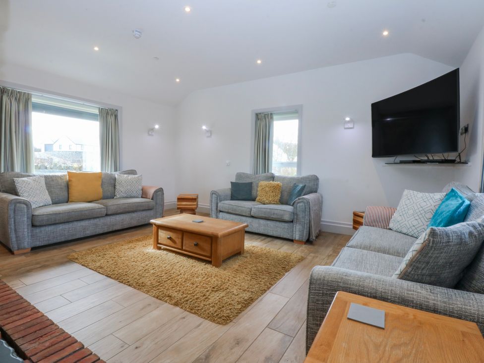 A living room with sofas and a coffee table at Bwthyn Alberts in Trearddur Bay
