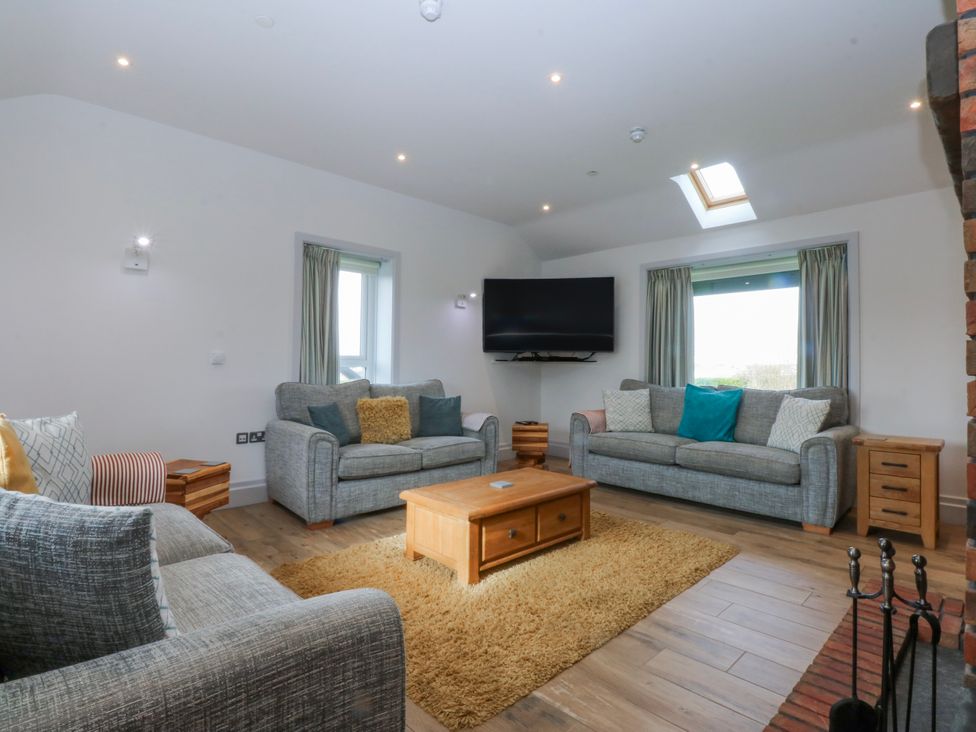 A living room with a sofa and coffee table at Bwthyn Alberts in Trearddur Bay