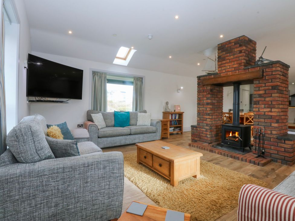 A living room with a fireplace and a sofa at Bwthyn Alberts in Trearddur Bay