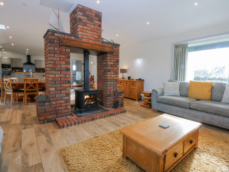 A living room with a fireplace and sofa at Bwthyn Alberts in Trearddur Bay