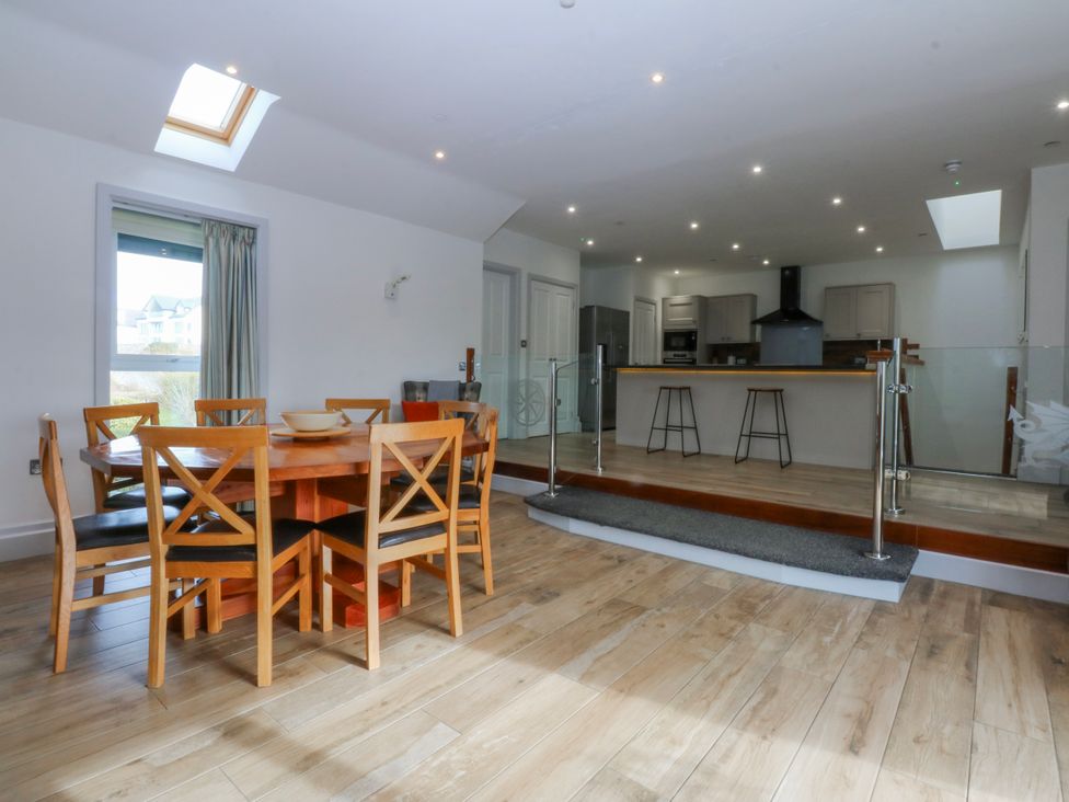 A dining room with a table and chairs at Bwthyn Alberts in Trearddur Bay