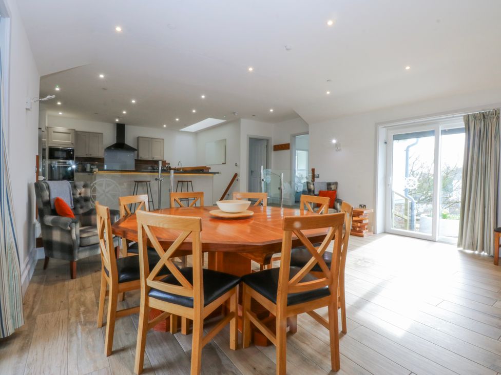A dining room with a table and chairs at Bwthyn Alberts in Trearddur Bay