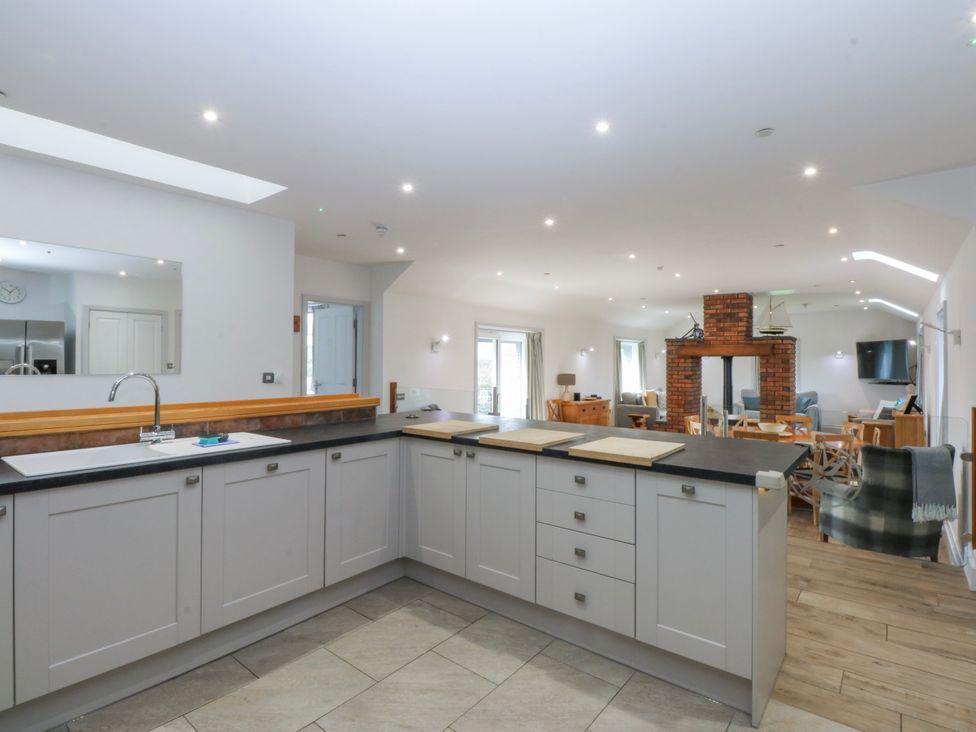 A kitchen with cabinets and sink at Bwthyn Alberts in Trearddur Bay