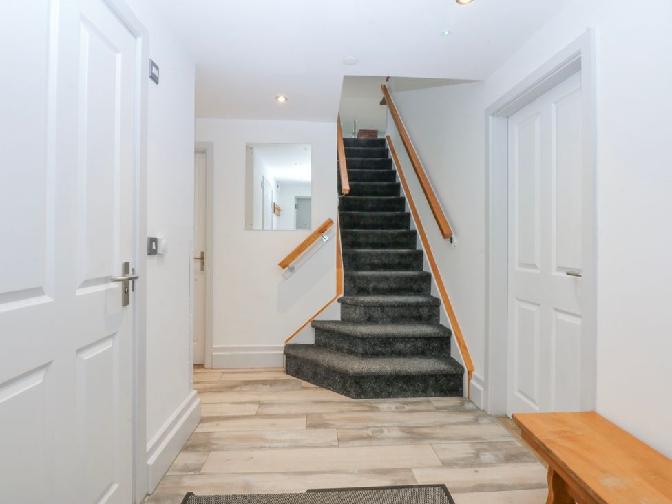 A hallway with stairs and doors at Bwthyn Alberts in Trearddur Bay