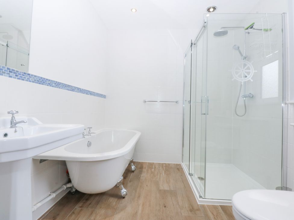 A bathroom with a bathtub, shower, sink, and toilet at Bwthyn Alberts in Trearddur Bay