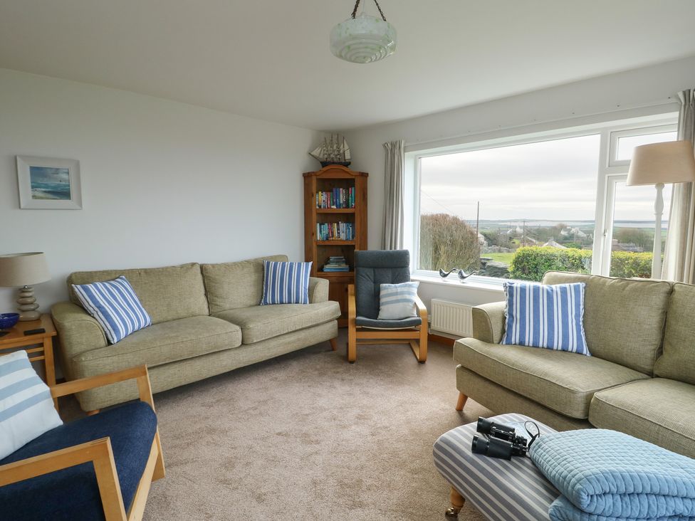 A living room with sofas and a bookshelf at Yr Orsedd in Llanfaethlu