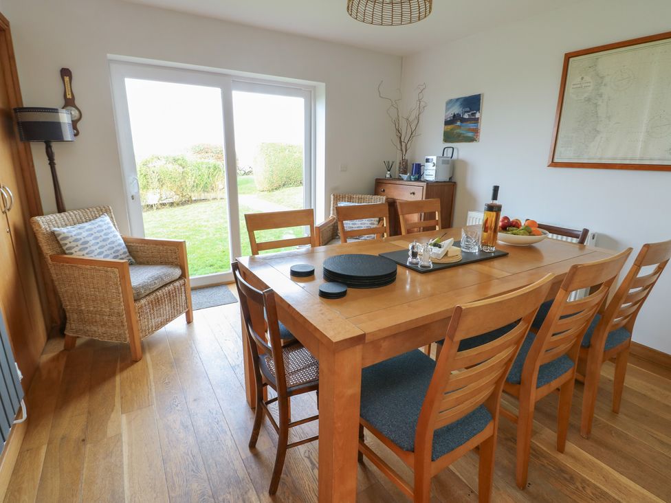 A dining room with a table and chairs at Yr Orsedd in Llanfaethlu