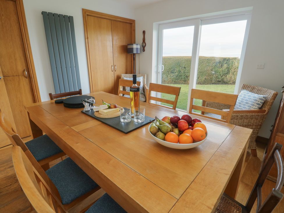 A dining room with a table set with fruit and drinks at Yr Orsedd Llanfaethlu