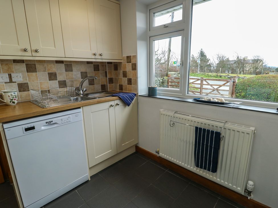 A kitchen with a sink and dishwasher at Yr Orsedd in Llanfaethlu