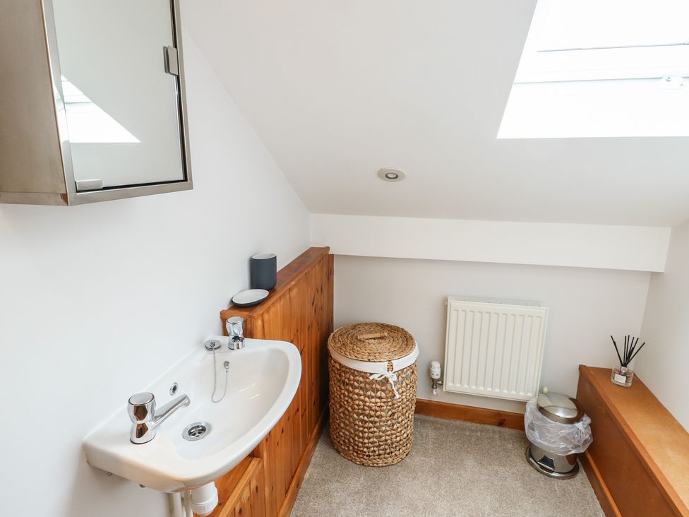A bathroom with sink and mirror at Yr Orsedd in Llanfaethlu