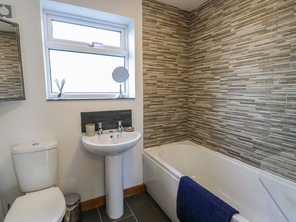 A bathroom with a sink, toilet, and bathtub at Yr Orsedd in Llanfaethlu