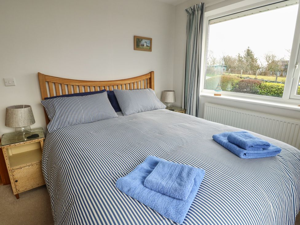 A bedroom with a bed and towels at Yr Orsedd in Llanfaethlu
