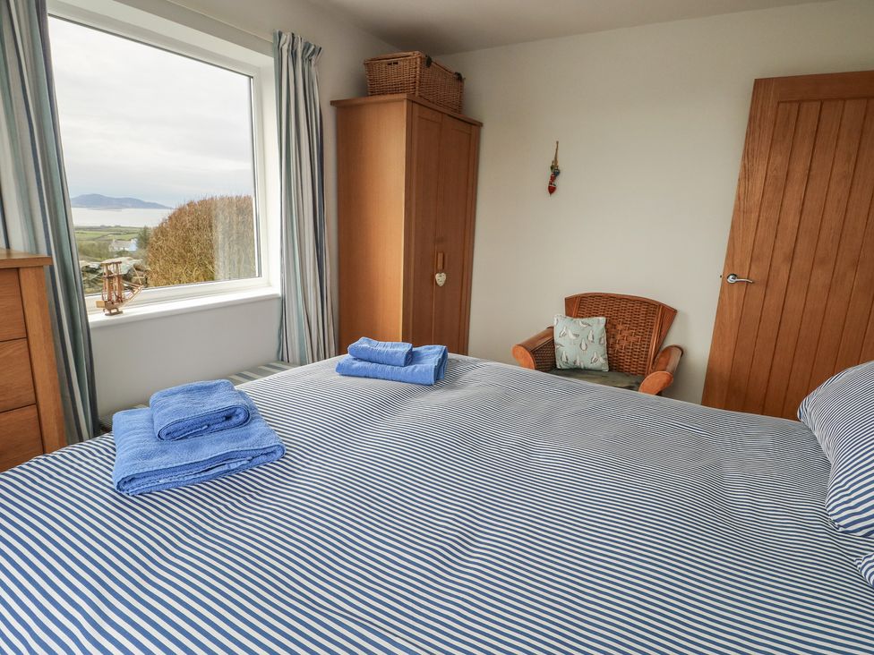 A bedroom with a bed and towels on top at Yr Orsedd in Llanfaethlu