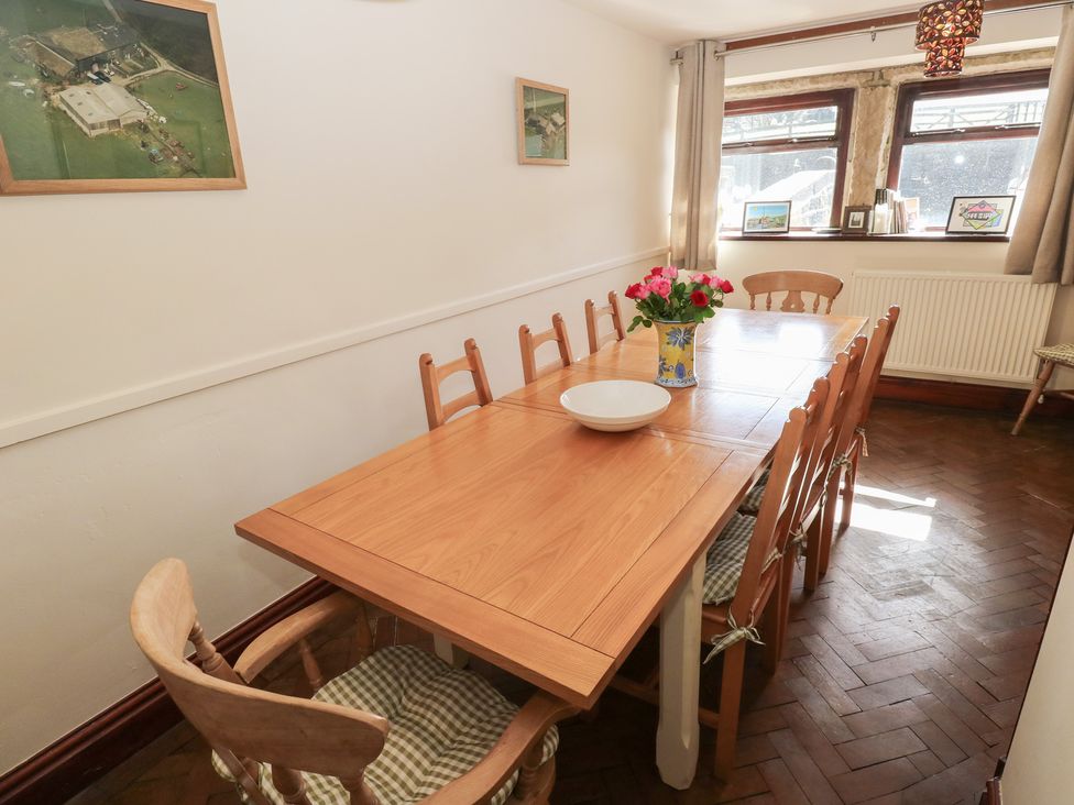 A dining room with a wooden table and chairs at Shoebroad Barn Todmorden